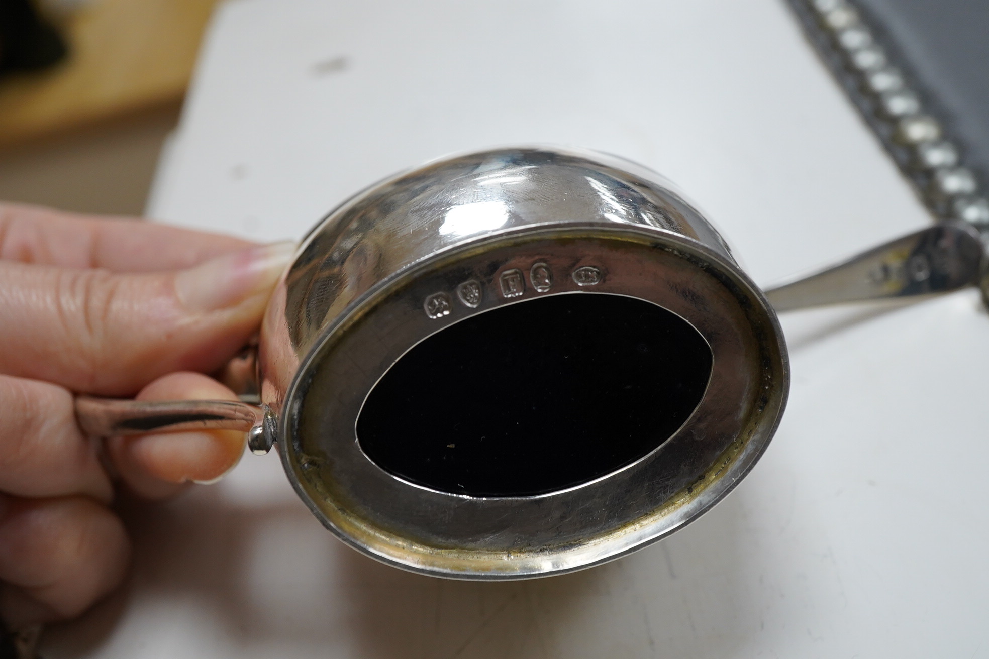 A George III engraved oval silver mustard pot, by James Mince, London, 1805, height 69mm, together with an associated silver mustard ladle, Thomas Dicks, London, 1808.